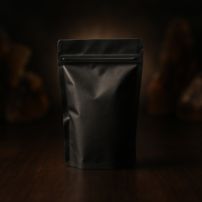 Photographie artistique premium d’un petit sachet kraft noir élégant et scellé, posé sur une table en bois sombre. La lumière met en valeur un léger halo autour du sachet, créant une ambiance mystérieuse et raffinée. En arrière-plan flouté : silhouettes abstraites de morceaux de résine sans détail précis. Atmosphère intrigante, sensorielle et premium, style photographie réaliste haute résolution. Pas de texte.